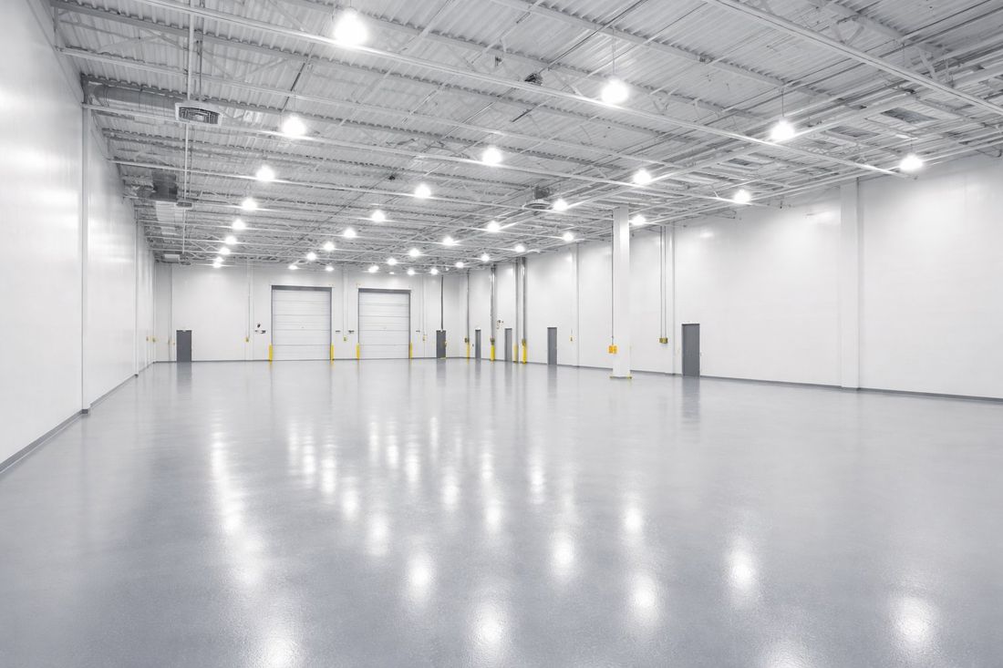 Interior de nave industrial con paredes y suelo recién pintados en Tarragona